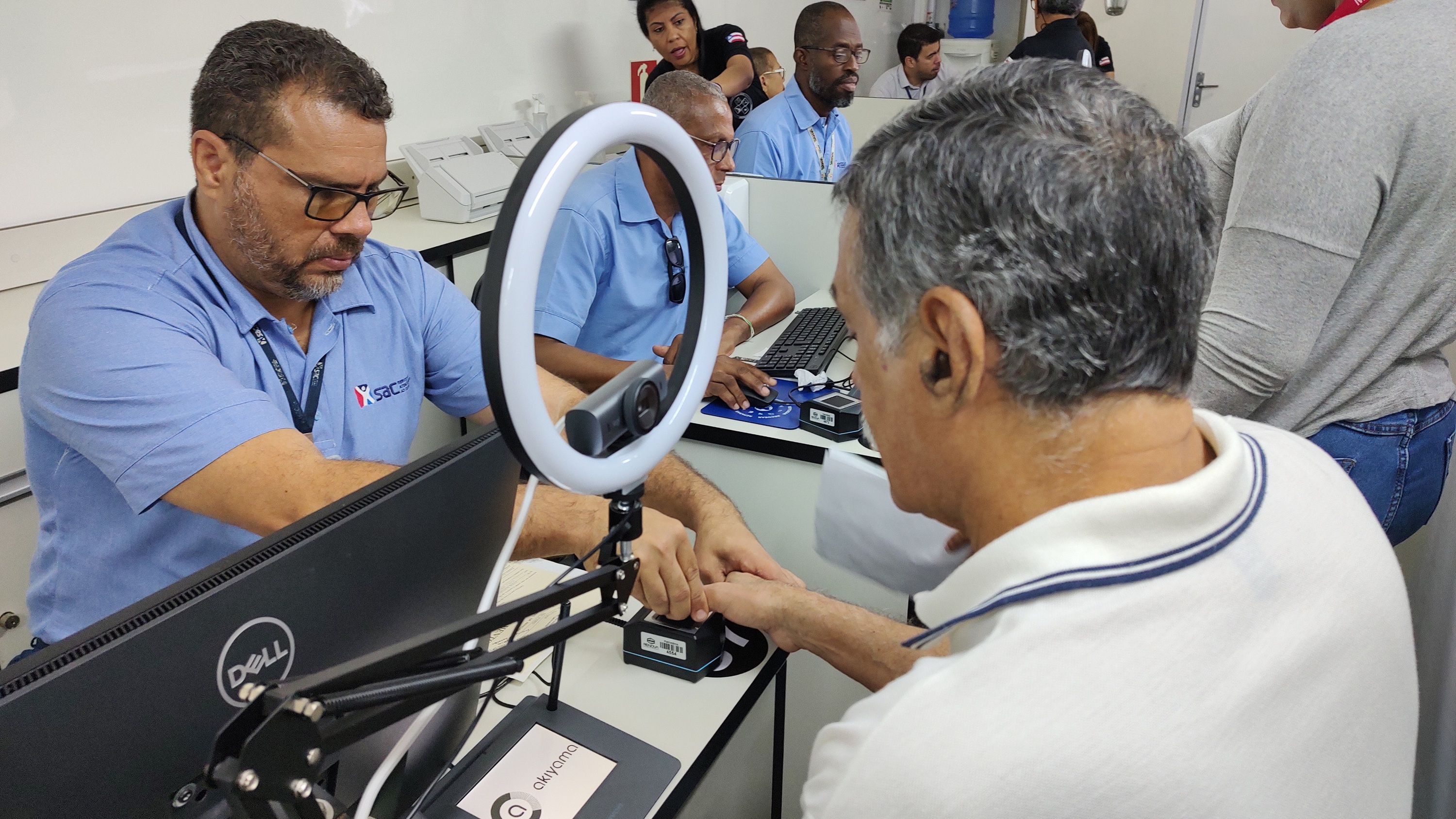 Colaborador do SAC, utilizando a farda azul da rede, atende cidadão no SAC Móvel