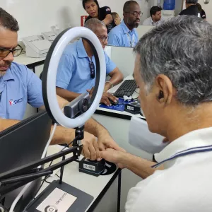 Colaborador do SAC, utilizando a farda azul da rede, atende cidadão no SAC Móvel