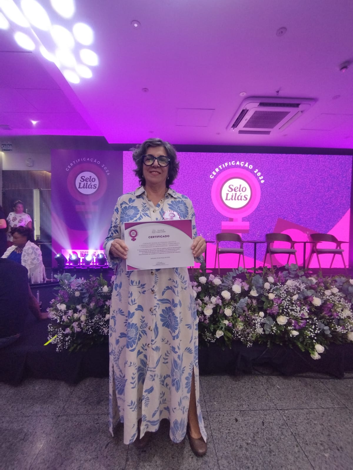 Diretora de Pesquisa Gisélia Souza representa a Bahiafarma durante cerimônia de cerificação com o Selo Lilás
