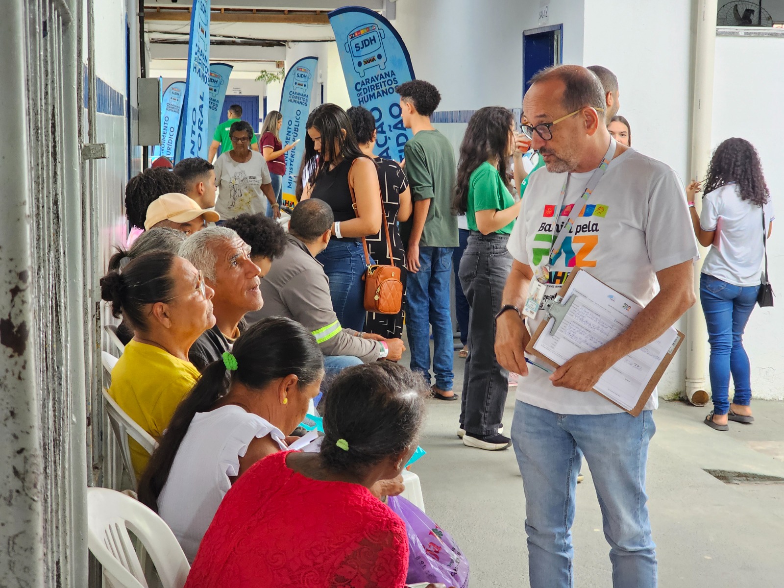 Público sentado conversa com o técnico, em pé.