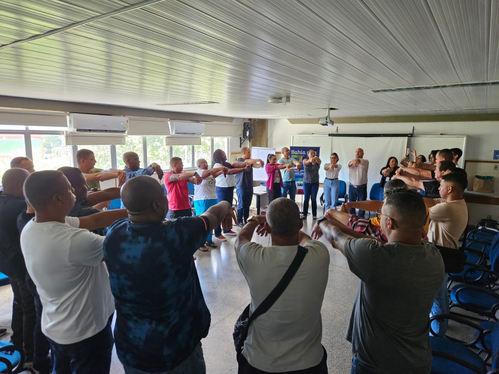 Pessoal em roda, fazendo alongamento