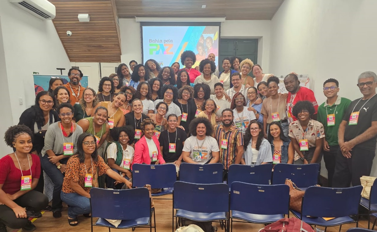 Foto dos técnicos como logo Bahia pela Paz ao fundo