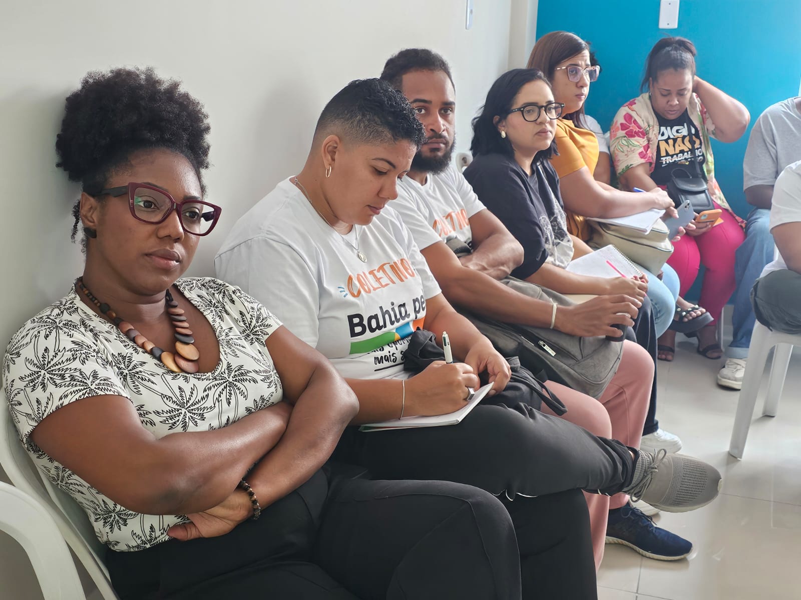 Alunos sentados, com camiseta dos Coletivos Bahia pela Paz, anotando e prestando atenção à aula.