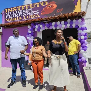 Foto da fachada do Instituto Maria Luíza, com duas mulheres e um homem de mãos dadas.