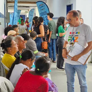 Público sentado conversa com o técnico, em pé.