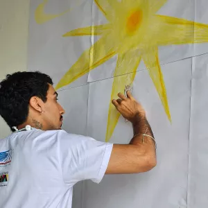 Artista pintando um sol amarelo
