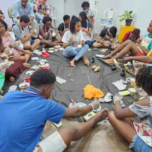 Jovens em roda, pintando cabaças