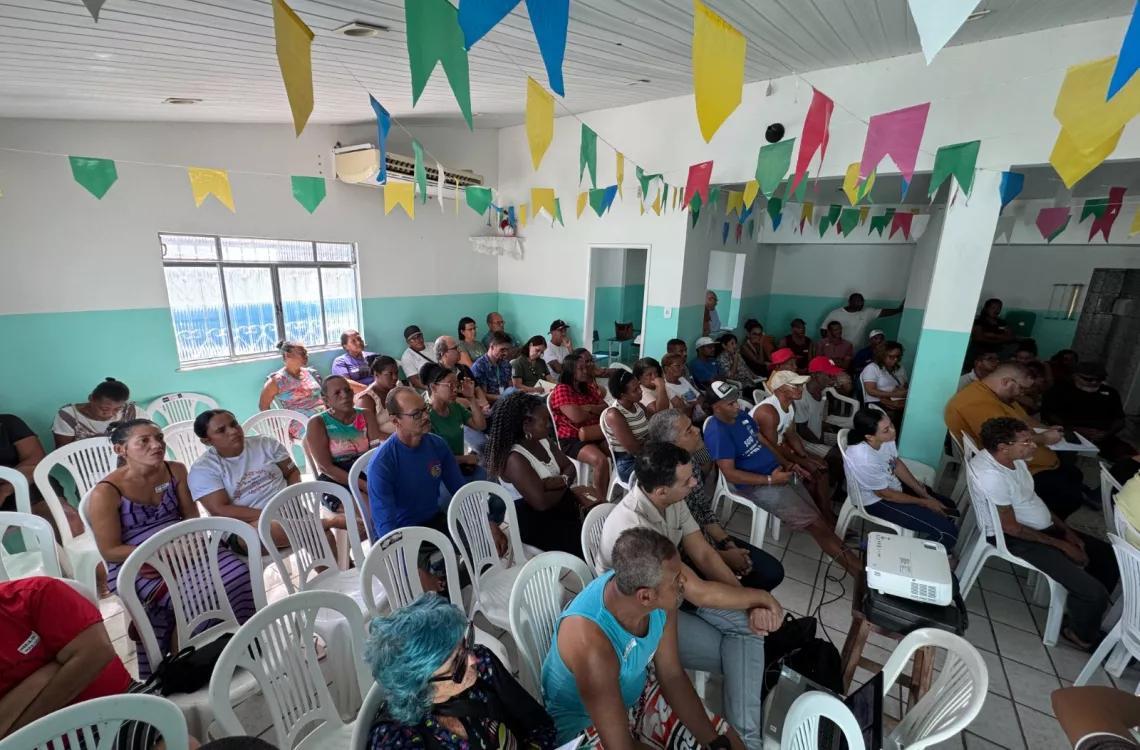 moradores da comunidade sentados durante a reunião