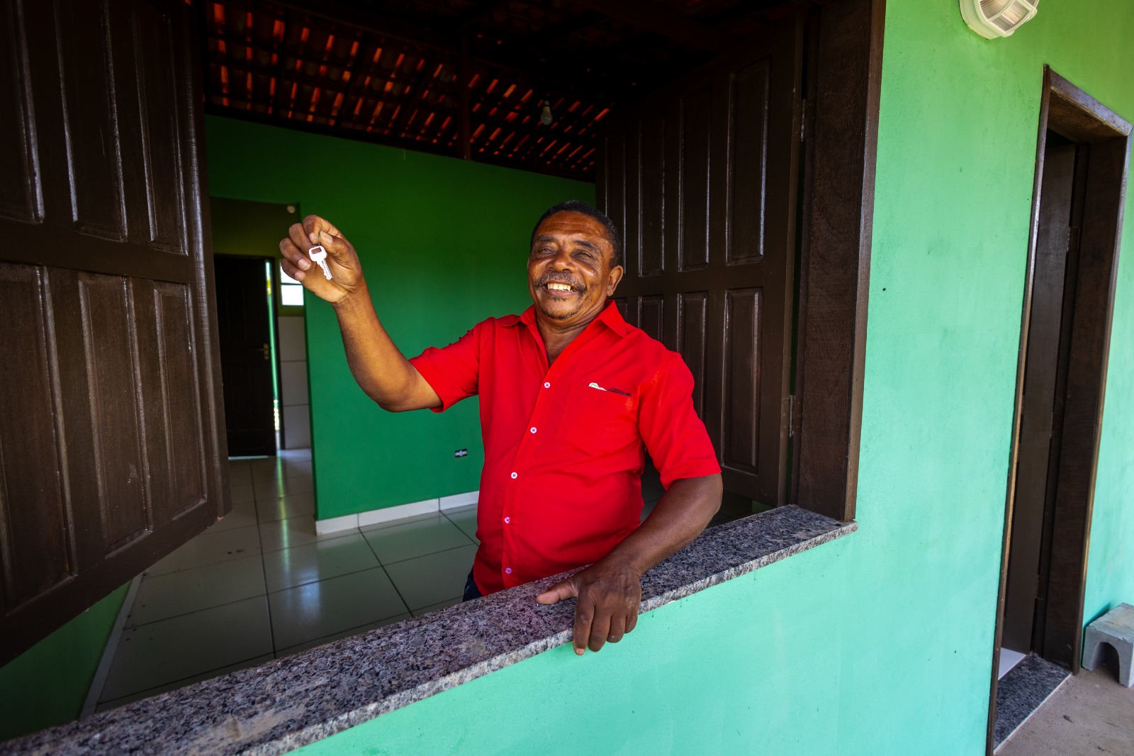 Beneficiário dentro da casa mostrando a chave