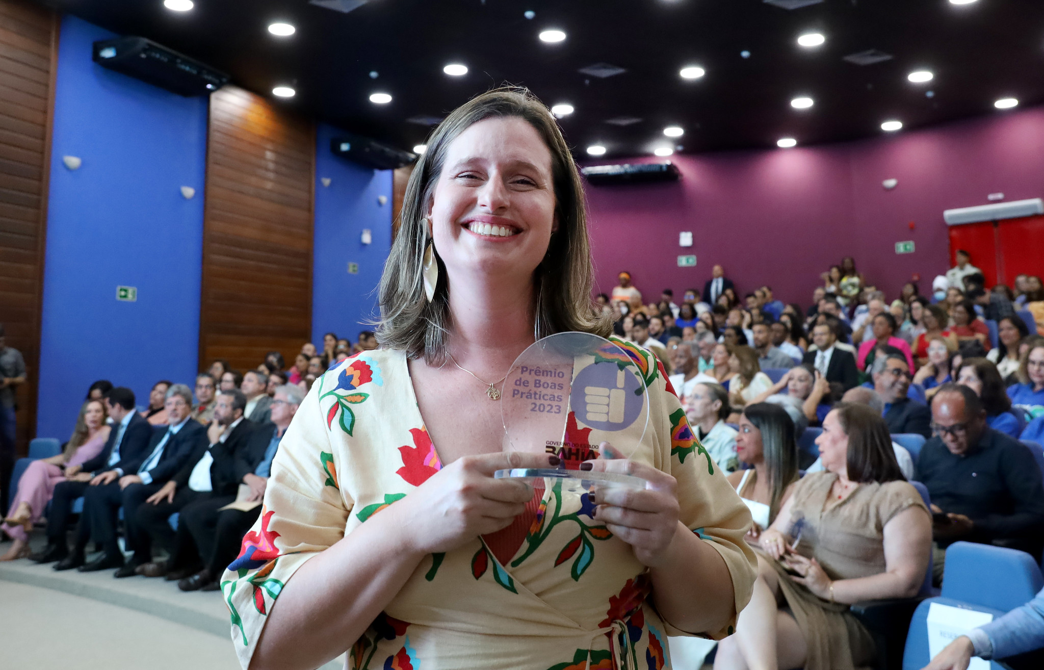 Foto de servidora com placa da premiação 
