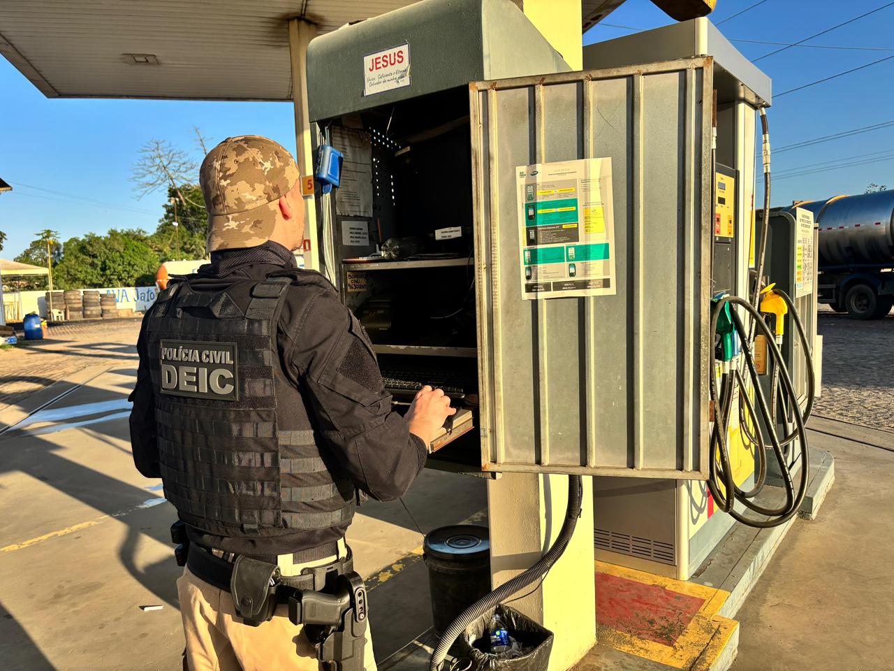 imagem de policial analisando computador em posto de combustível