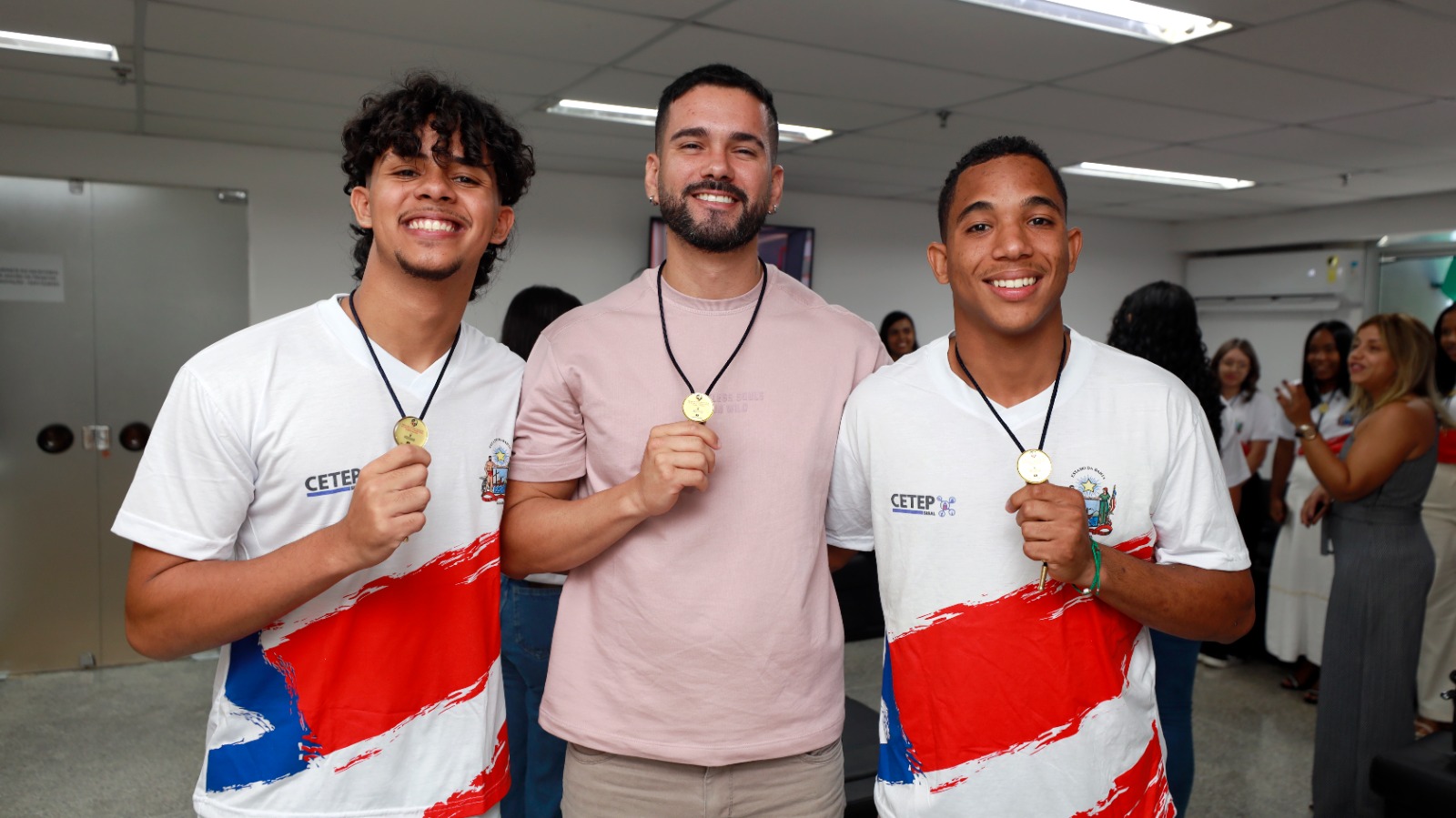 três estudantes exibindo as medalhas 
