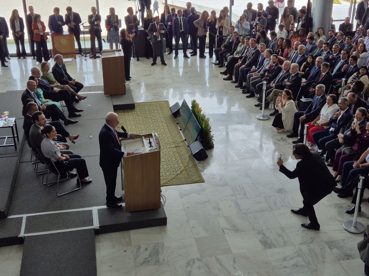 Foto do evento com presidente Lula falando e público