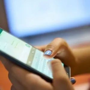 Foto de mãos segurando o celular para representar que o Governo do Estado antecipa o pagamento de 50% dos salários dos servidores públicos