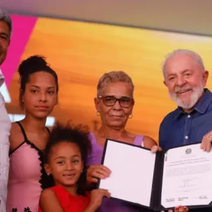 Foto do governador, presidente e família beneficiada