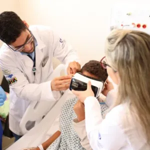 Médicos posicionam óculos em paciente 