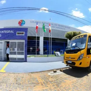 Foto da frente do colégio e do ônibus escolar 