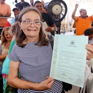 Mulher com seu titulo de terra nas mãos