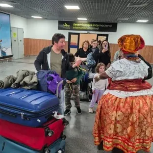 foto de turistas chegando ao aeroporto e sendo recepcionados por baiana