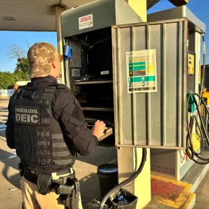 imagem de policial analisando computador em posto de combustível