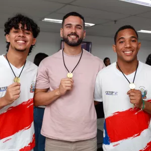três estudantes exibindo as medalhas 