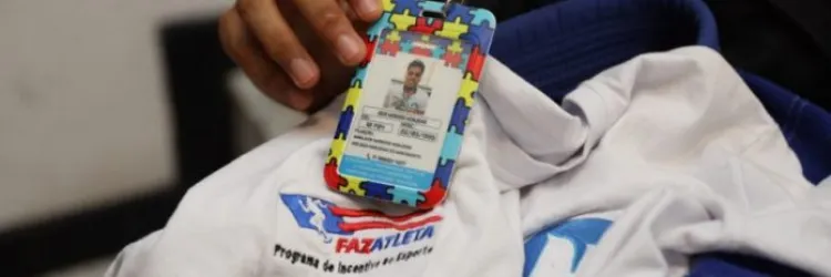 Foto de camisa do programa e mão de atleta segurando o crachá 