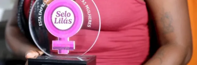 foto mulher segurando premiação do Selo