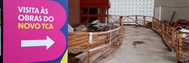 Foto com placa e corredor indicando obras do TCA