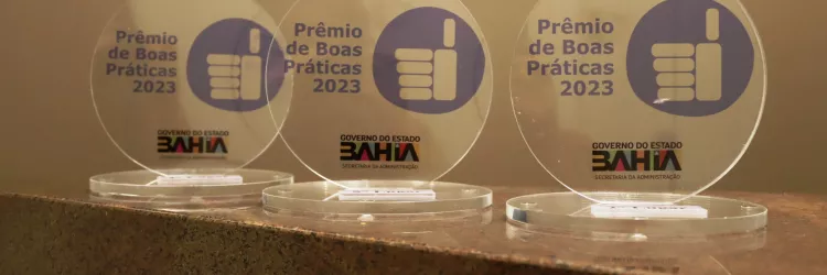 imagem de três placas do prêmio de boas práticas
