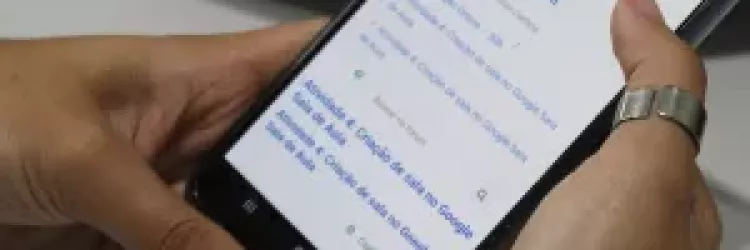 foto de mão segurando o celular com endereço site da inscrição