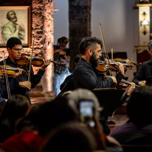 OSBA leva música clássica e poesia à Feira Literária de Mucugê em concerto gratuito neste sábado (16)     Apresentação integra a programação da Fligê 2025 e acontecerá na Igreja Matriz, às 19h; programa terá obras de Bach e Mozart, além de poemas de Gregório de Matos    Site---Osba-na-Estrada---FLIGÊ---VOZES-DO-SAGRADO.png   A Orquestra Sinfônica da Bahia (OSBA) vai até a região da Chapada Diamantina neste sábado, 16 de agosto, para uma apresentação especial que mescla música clássica e poesia dentro da pro