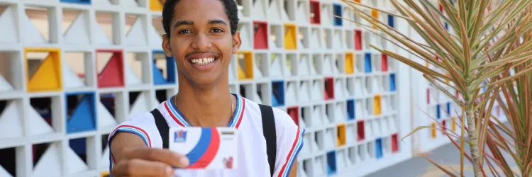 estudante segura e mostra o cartão bolsa presença 