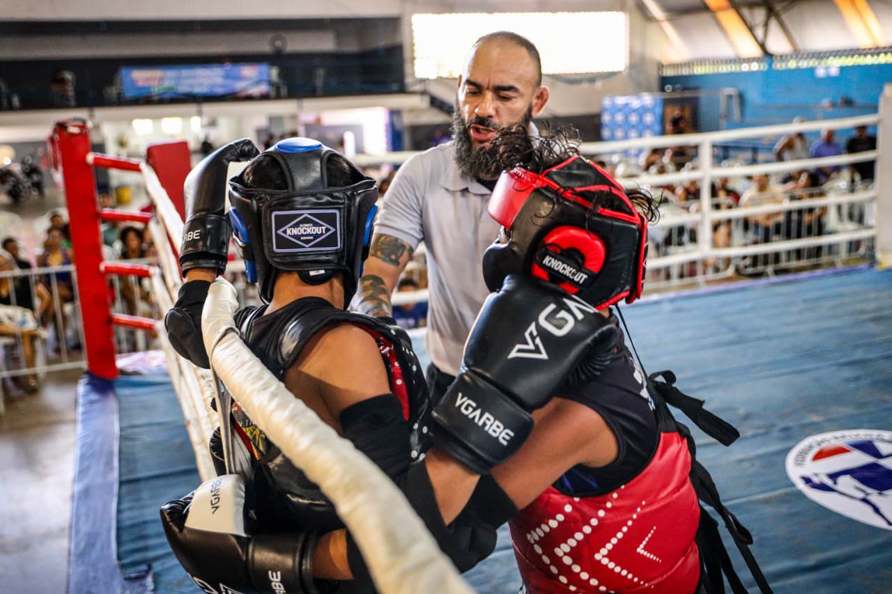 pessoas encostada em uma alambrado se preparando para disputa  