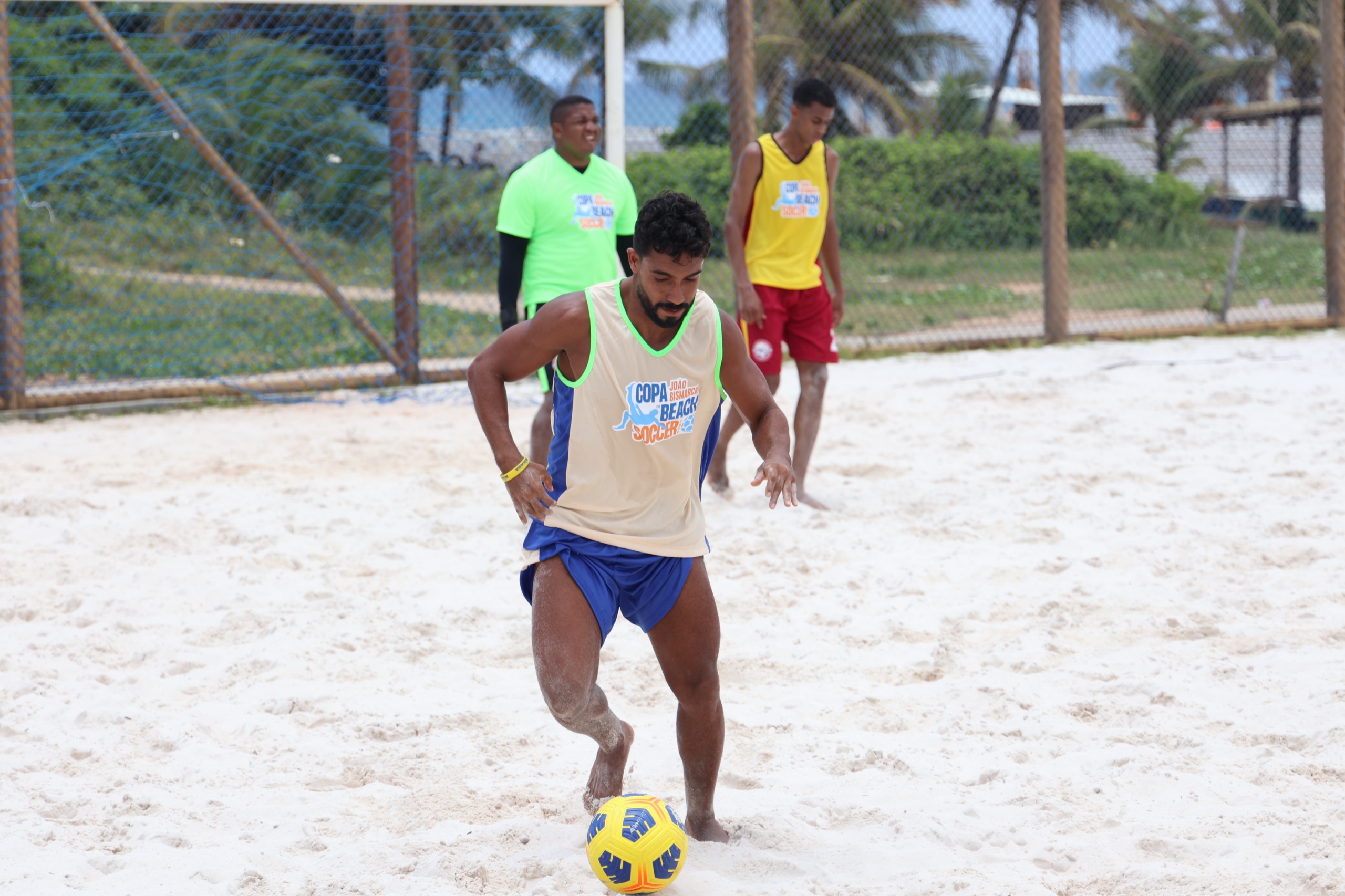 rapaz na areia indo em direção a bola 