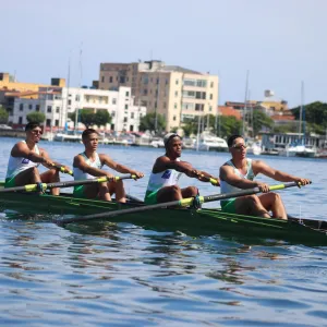 quatro homens em uma barco remando