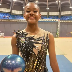 menina em pé com bola na mão 