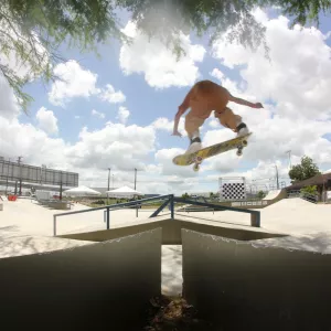 menino fazendo manobra de skate 