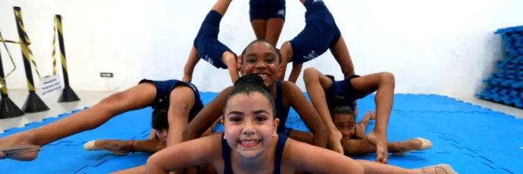 Meninas de 7 anos praticando ginástica. Maior parte delas está no solo