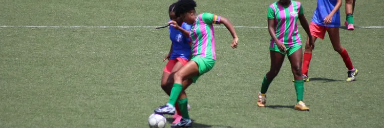 duas meninas disputando bola de futebol 