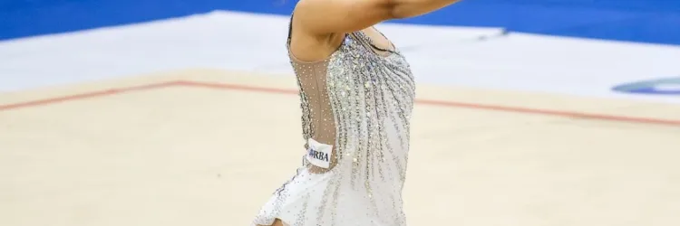 menina no chão de joelhos segurando uma bola vermelha 