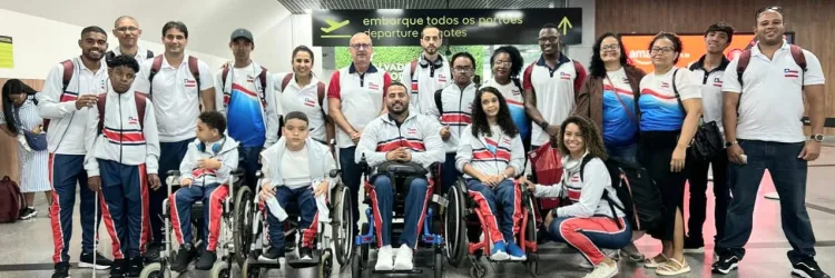 pessoas em pé e mais quatro pessoas na frente sentadas em cadeiras de rodas