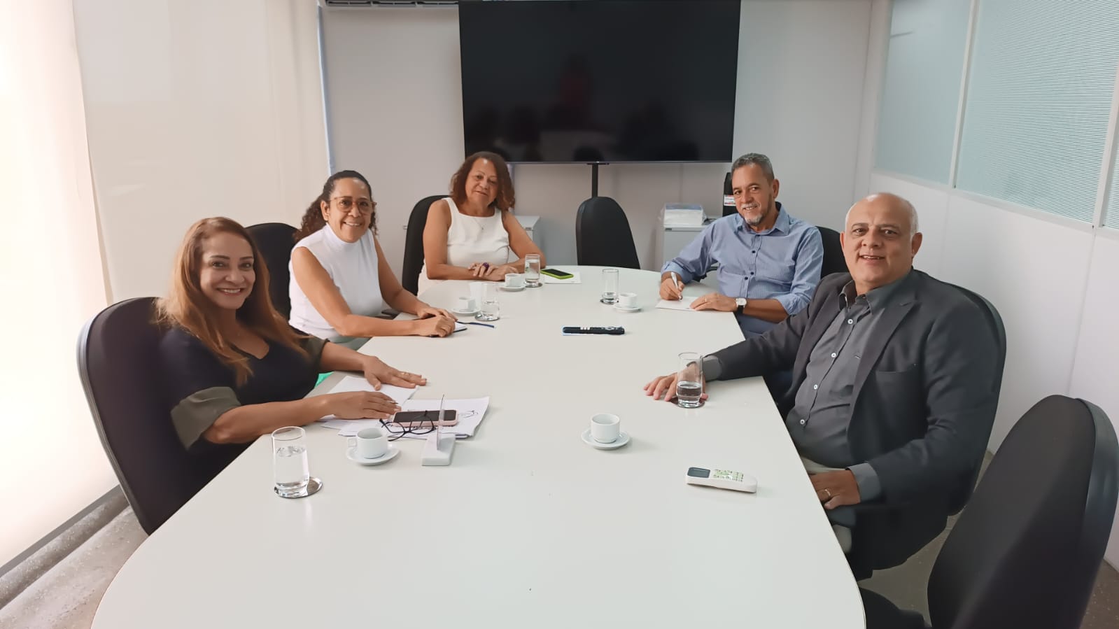 Pessoas reunidas, sentadas à mesa