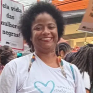 hildete nogueira na marcha das mulheres negras. Ela está vestida de branco, é uma mulher negra e segura uma ventarola da campanha coração azul 
