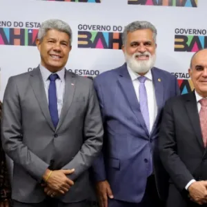 Governo da Bahia e TST em diálogo: representantes dos poderes executivo estadual e judiciário posam a frente do banner com a logo do governo do estado