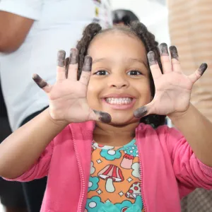 menina com os dedos pintados para fazer rg. Caravana de Direitos Humanos.
