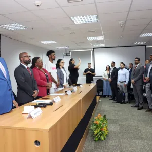 Secretário felipe no II Encontro Sinase. ele veste terno azul e está em pé, é um homem negro que usa óculos. 