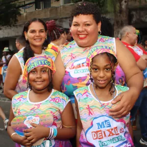 quatro epssoas na foto usando a camisa do bloco me deixe a vontade, nas cores azul, verde e laranja. uma dela usa uma bandana da campanha respeito é nosso direito. 