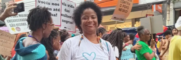 hildete nogueira na marcha das mulheres negras. Ela está vestida de branco, é uma mulher negra e segura uma ventarola da campanha coração azul 