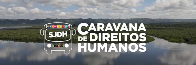  A imagem mostra o logotipo da "Caravana de Direitos Humanos" em destaque, com a sigla "SJDH" (Secretaria de Justiça e Direitos Humanos) dentro de um ícone de ônibus estilizado, representando o projeto itinerante. O fundo exibe uma paisagem natural, com um rio ou lago refletindo o céu azul e nuvens, cercado por vegetação densa e montanhas ao longe.