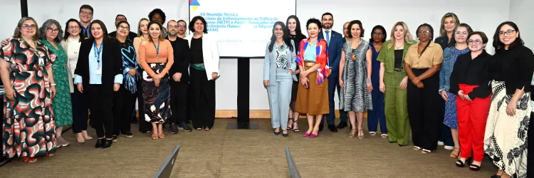 pessoas reunidas frente a um cartas sobre a Reunião Técnica de Enfrentamento ao Tráfico de Pessoas